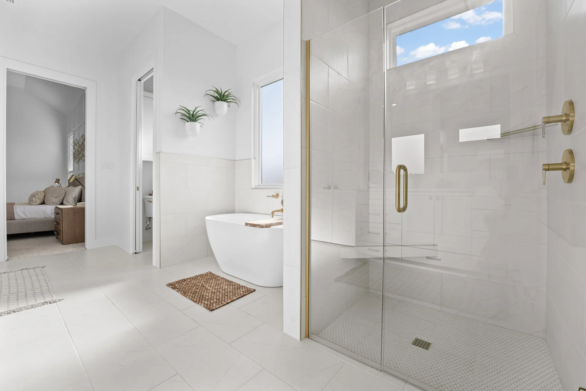 Primary suite bathroom with walk in shower and elegant tub