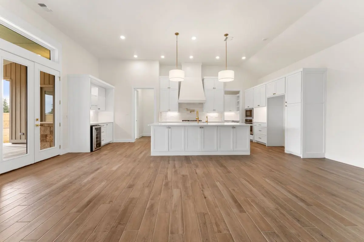Kitchen view of a premium-designed home for The Vineyard Preserve. Featuring all-white cabinets with a spacious kitchen island. 