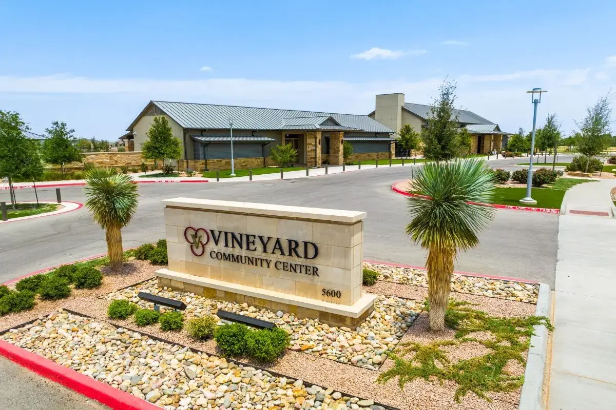Sign of The Vineyard Preserve's community center with the center shown in the background. 